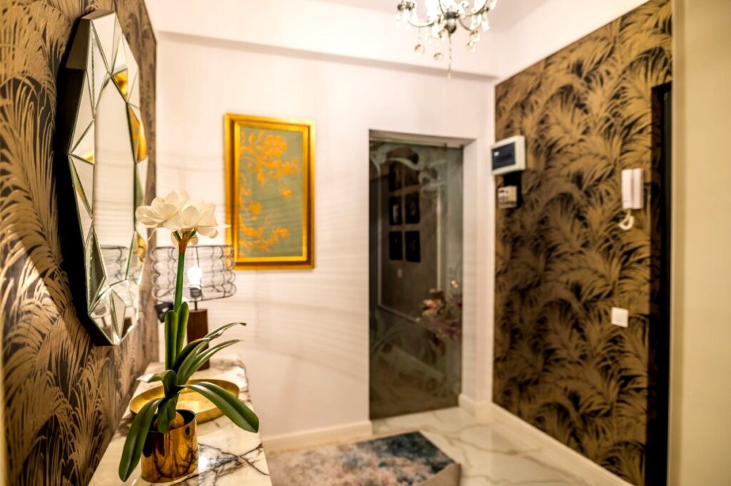 Accente glam sunt realizate prin intermediul tapetului cu modele spectaculoase, candelabrelor şi oglinzilor