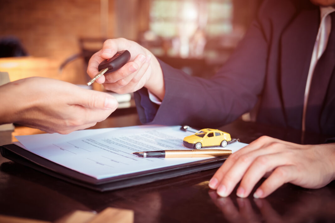 Car,Salesman,Holding,Key,To,His,Client,After,Signing,Contract,concept