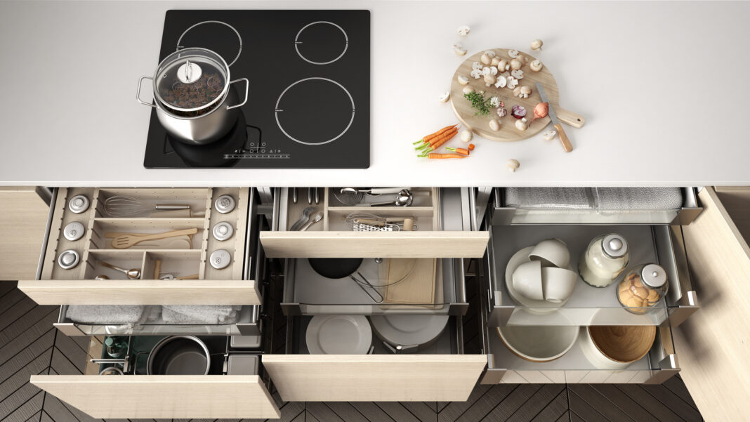 Opened wooden kitchen drawer with accessories inside, solution f