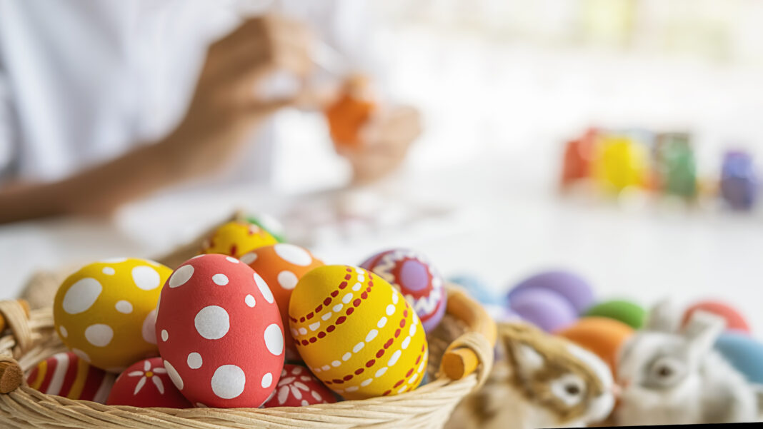 Easter eggs and Decoration on white desk with happy woman painting eggs background. Family preparing for Easter.