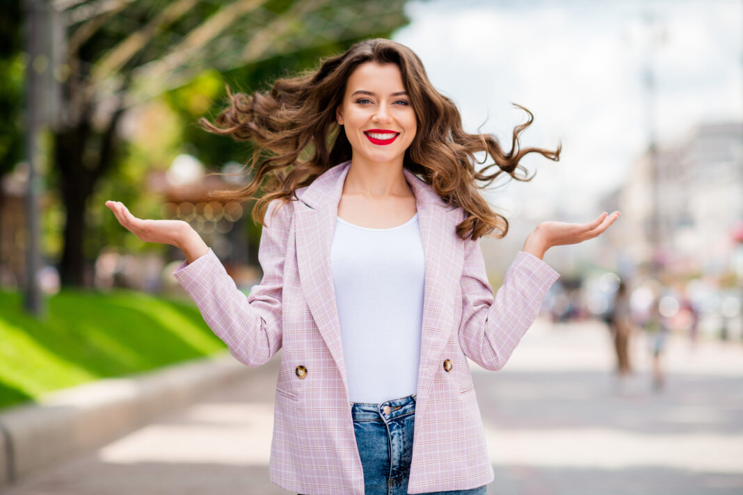 Portrait of her she nice-looking attractive lovely charming trendy glamorous fashionable dreamy cheerful cheery glad wavy-haired lady enjoying fresh air in downtown outdoors